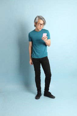 Mavi arka plandaki kıdemli Asyalı adam..