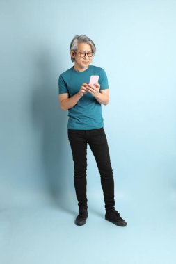 Mavi arka plandaki kıdemli Asyalı adam..