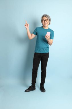 Mavi arka plandaki kıdemli Asyalı adam..