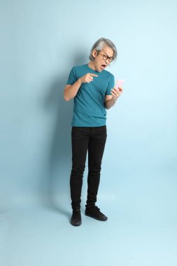 Mavi arka plandaki kıdemli Asyalı adam..