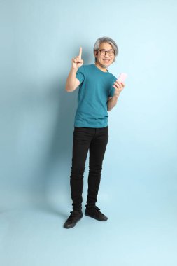 Mavi arka plandaki kıdemli Asyalı adam..