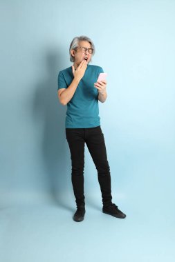 Mavi arka plandaki kıdemli Asyalı adam..