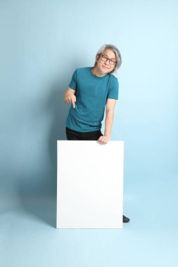 Mavi arka plandaki kıdemli Asyalı adam..