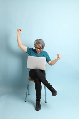 Mavi arka plandaki kıdemli Asyalı adam..