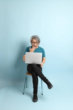 Mavi arka plandaki kıdemli Asyalı adam..