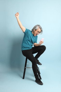 Mavi arka plandaki kıdemli Asyalı adam..