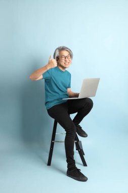 Mavi arka plandaki kıdemli Asyalı adam..