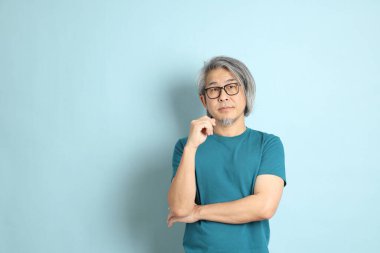 Mavi arka plandaki kıdemli Asyalı adam..