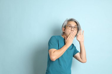 Mavi arka plandaki kıdemli Asyalı adam..