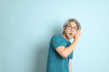 Mavi arka plandaki kıdemli Asyalı adam..