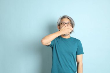 Mavi arka plandaki kıdemli Asyalı adam..