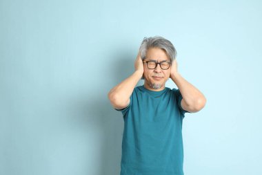 Mavi arka plandaki kıdemli Asyalı adam..