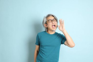 Mavi arka plandaki kıdemli Asyalı adam..