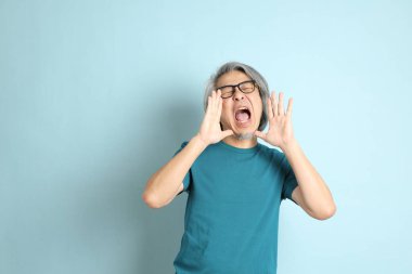 Mavi arka plandaki kıdemli Asyalı adam..