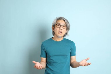 Mavi arka plandaki kıdemli Asyalı adam..