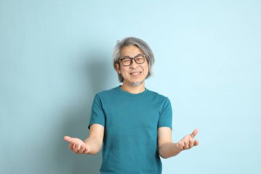 Mavi arka plandaki kıdemli Asyalı adam..