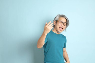 Mavi arka plandaki kıdemli Asyalı adam..