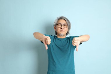 Mavi arka plandaki kıdemli Asyalı adam..