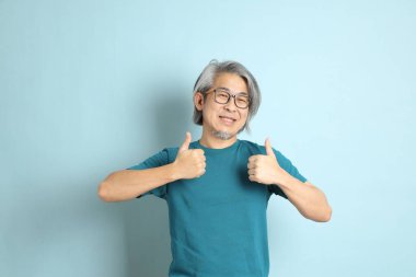 Mavi arka plandaki kıdemli Asyalı adam..