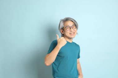 Mavi arka plandaki kıdemli Asyalı adam..