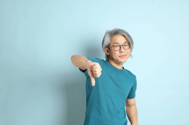 Mavi arka plandaki kıdemli Asyalı adam..