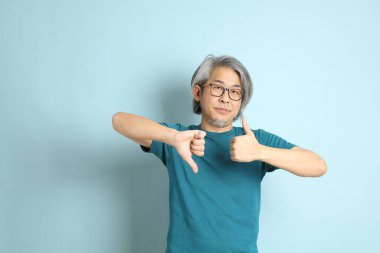 Mavi arka plandaki kıdemli Asyalı adam..