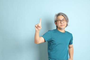 Mavi arka plandaki kıdemli Asyalı adam..