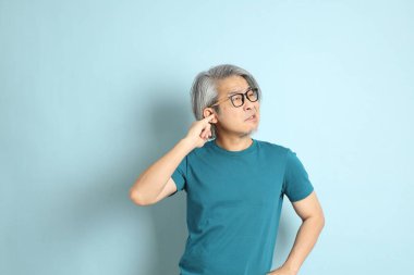 Mavi arka plandaki kıdemli Asyalı adam..