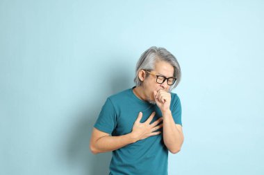 Mavi arka plandaki kıdemli Asyalı adam..