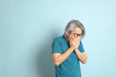 Mavi arka plandaki kıdemli Asyalı adam..