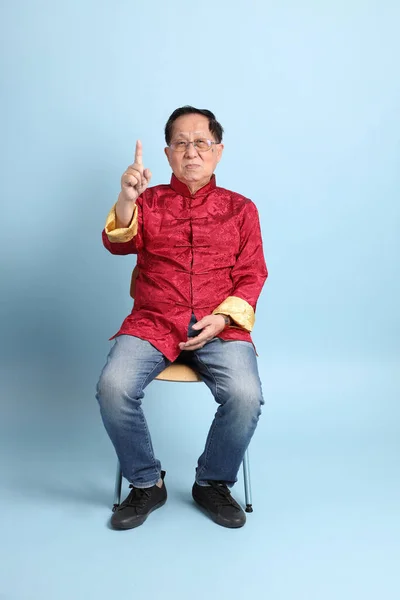 Senior Asian Man Wearing Traditional Chinese Shirt Sitting Blue Background — Stockfoto