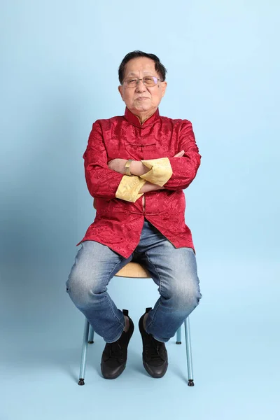 Homem Asiático Sênior Vestindo Camisa Chinesa Tradicional Sentado Fundo Azul — Fotografia de Stock