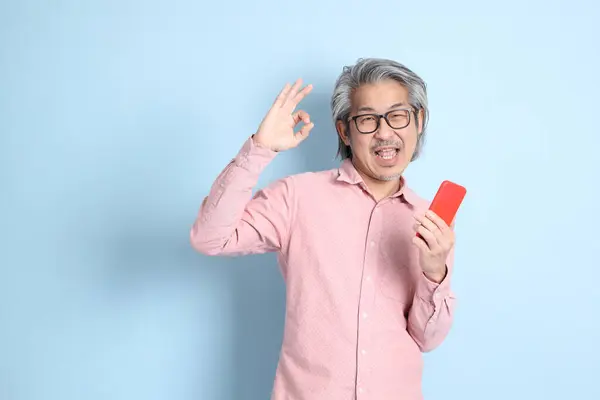 Homme Asiatique Senior Debout Sur Fond Bleu Avec Chemise Rose — Photo