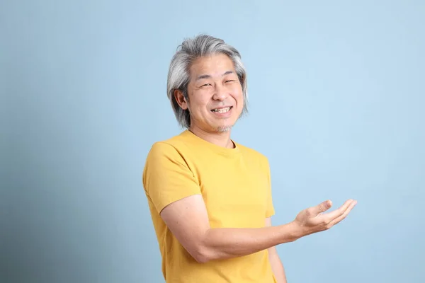 Homme Asiatique Senior Avec Shirt Jaune Debout Sur Fond Bleu — Photo