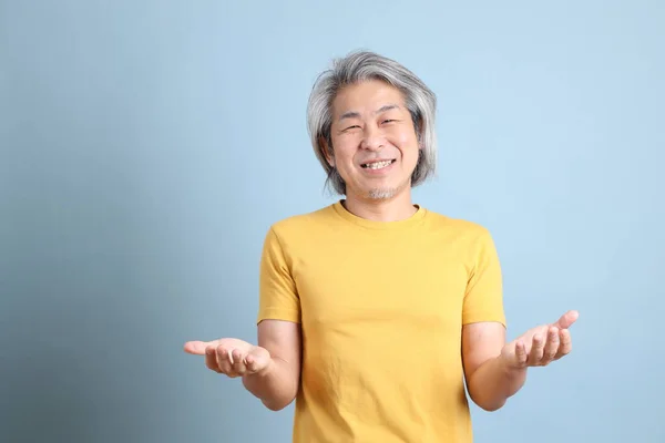 Senior Asian Man Yellow Shirt Standing Blue Background — Foto Stock