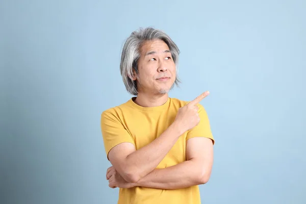 Senior Asian Man Yellow Shirt Standing Blue Background — Stok fotoğraf