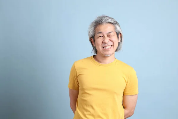 Homme Asiatique Senior Avec Shirt Jaune Debout Sur Fond Bleu — Photo