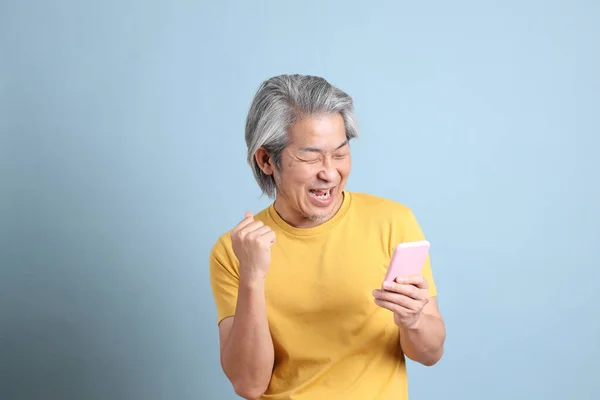 Senior Asian Man Yellow Shirt Standing Blue Background — Stockfoto