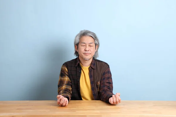 Den Ældre Asiatiske Mand Iført Den Gule Plaid Skjorte Sidder - Stock-foto
