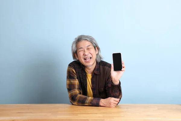 Der Ältere Asiatische Mann Mit Dem Smartphone Schreibtisch Mit Blauem — Stockfoto