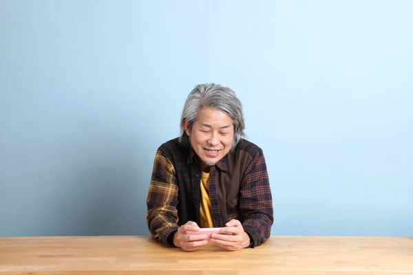 Uomo Asiatico Anziano Che Usa Smart Phone Alla Scrivania Con — Foto Stock