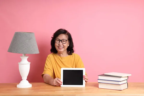 Mujer Asiática Mayor Usando Tableta Escritorio Sobre Fondo Rosa — Foto de Stock