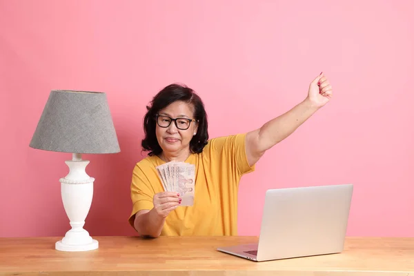 Senior Asian Woman Working Laptop Sitting Desk Pink Background — Stockfoto