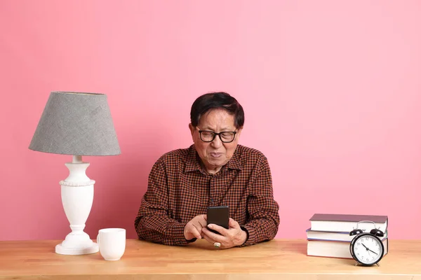 Uomo Asiatico Anziano Seduto Alla Scrivania Usando Smartphone Sullo Sfondo — Foto Stock