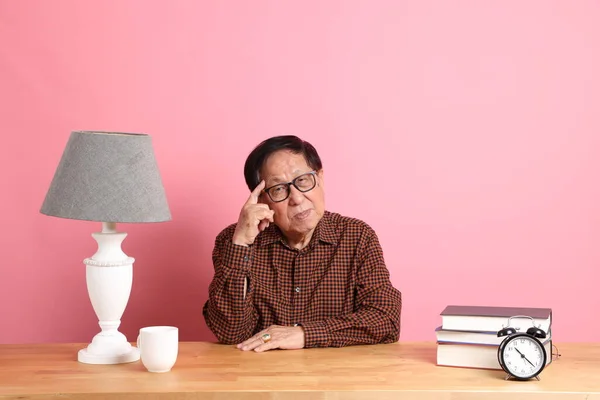 Uomo Asiatico Anziano Seduto Alla Scrivania Con Sfondo Rosa — Foto Stock