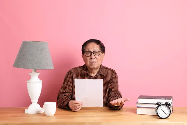 Uomo Asiatico Anziano Seduto Alla Scrivania Con Sfondo Rosa — Foto Stock