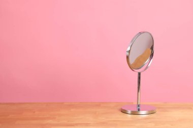 Masanın üzerindeki renk arkaplanlı çember şeklindeki ayna ayarı.