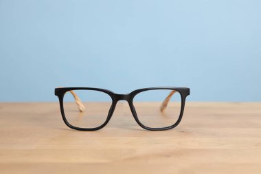 Ahşap masadaki renk arkaplanlı gözlük resmi..