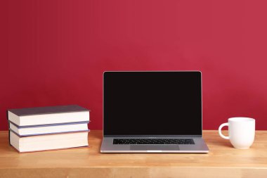 Masadaki renk arkaplanlı dizüstü bilgisayarın resmi.