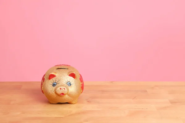 Das Goldene Sparschwein Auf Dem Schreibtisch Mit Rosa Hintergrund — Stockfoto